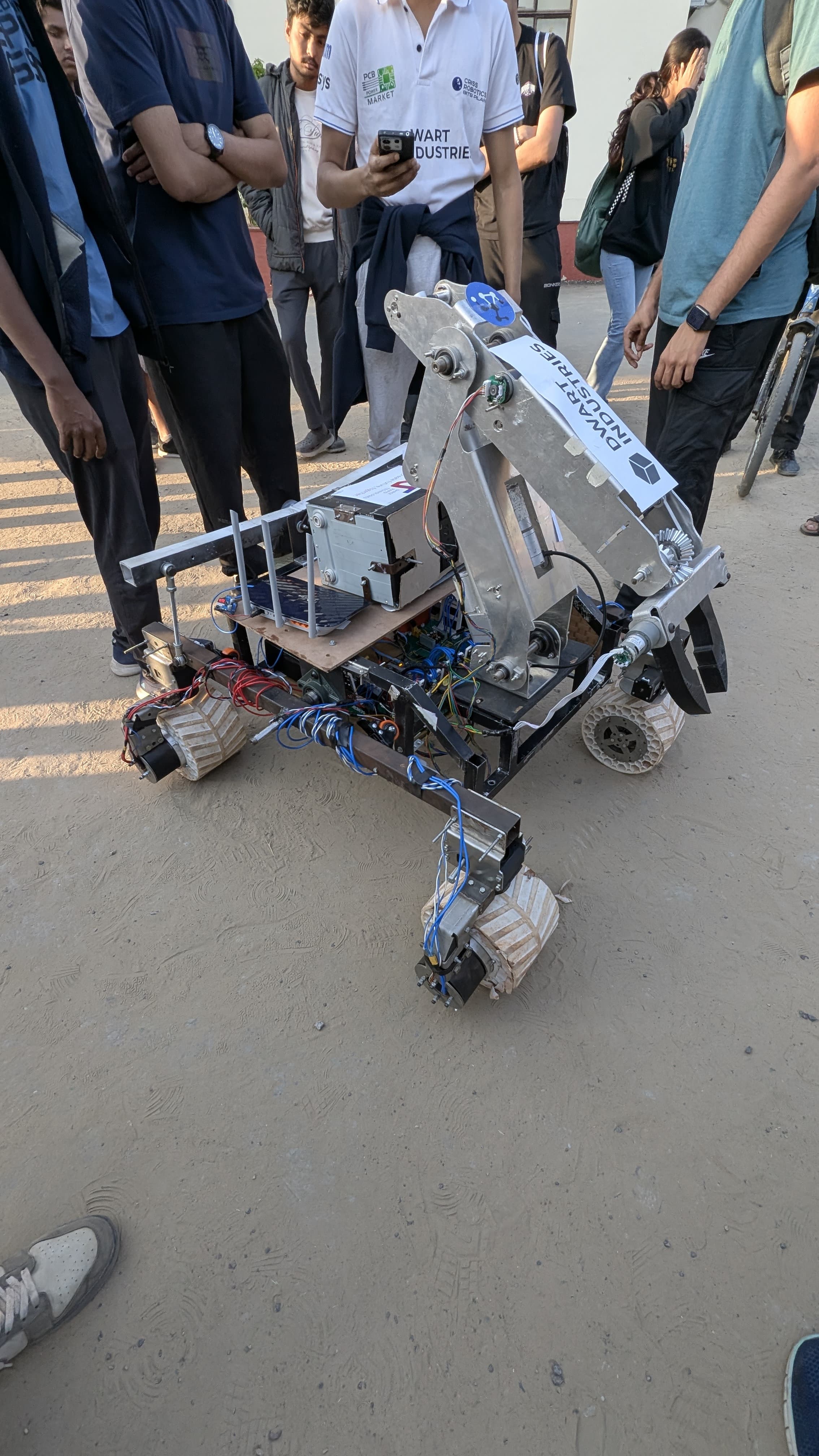 Full CRISS Robotics BITS Pilani team group photo with competition rover and sponsors banner at IRC 2025