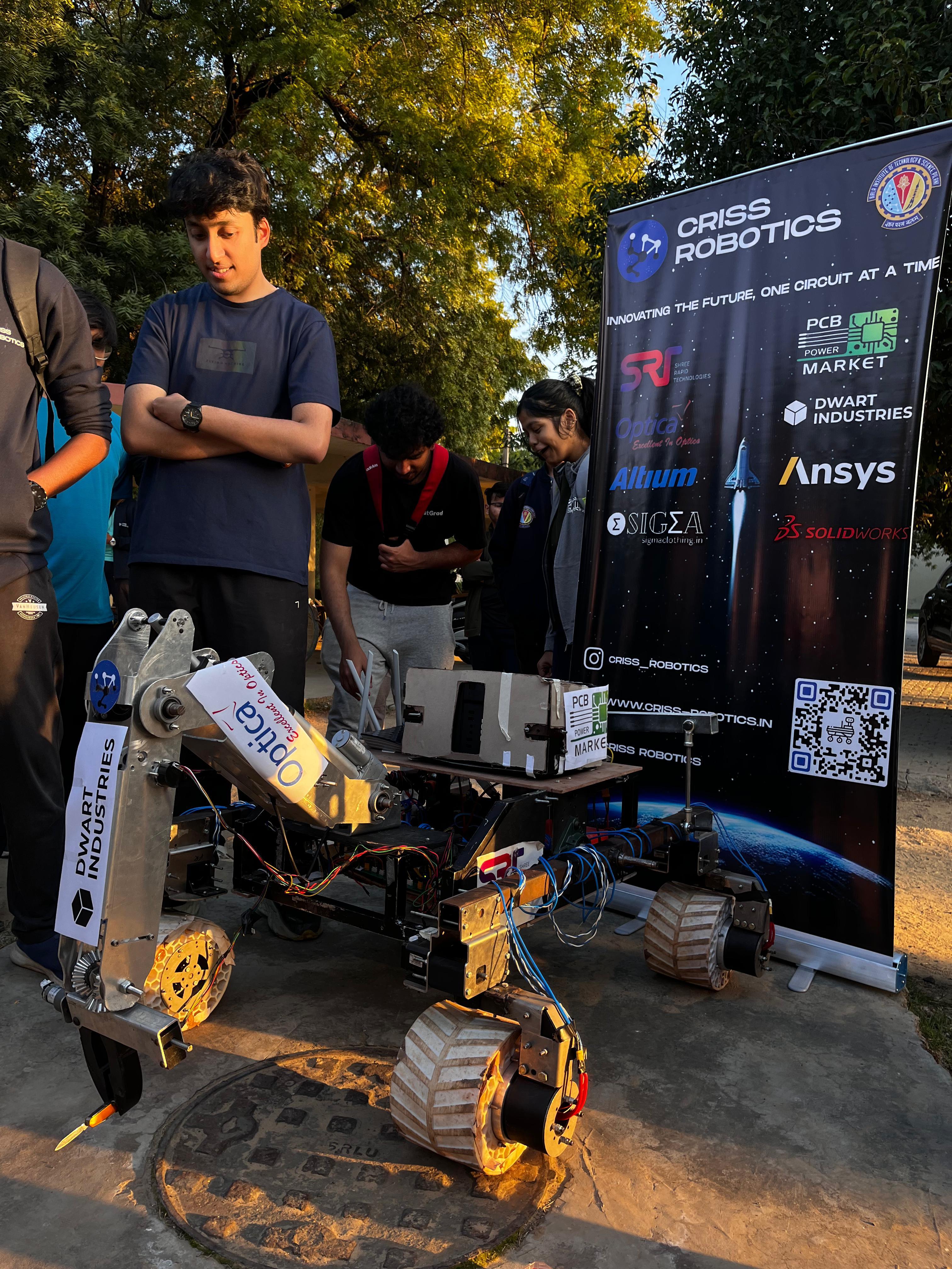 CRISS Robotics rover outdoors next to Dwart Industries sponsor banner at IRC 2025 BITS Pilani Goa