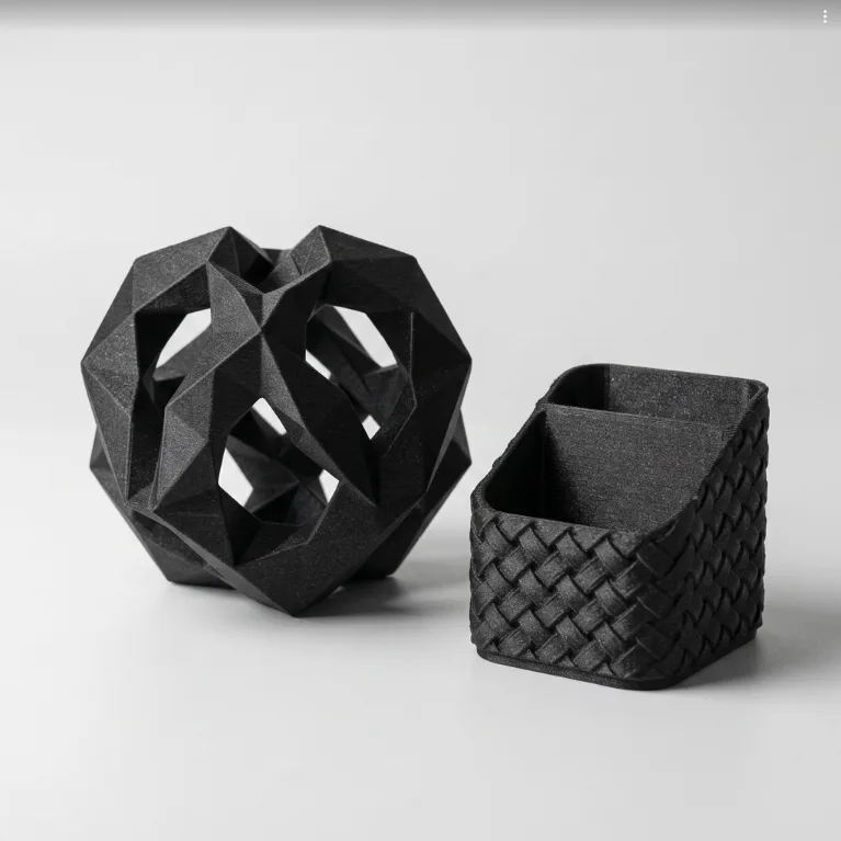 Assorted black PLA carbon fibre 3D printed components on a grey background